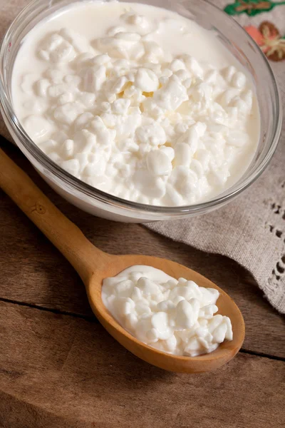 Cottage cheese in a plate and a spoon with cottage cheese — Stock Photo, Image