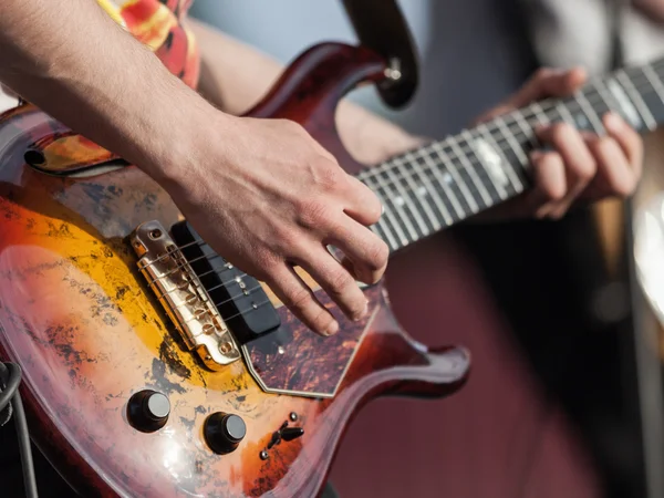 Mão humana segurando instrumento de música guitarra — Fotografia de Stock