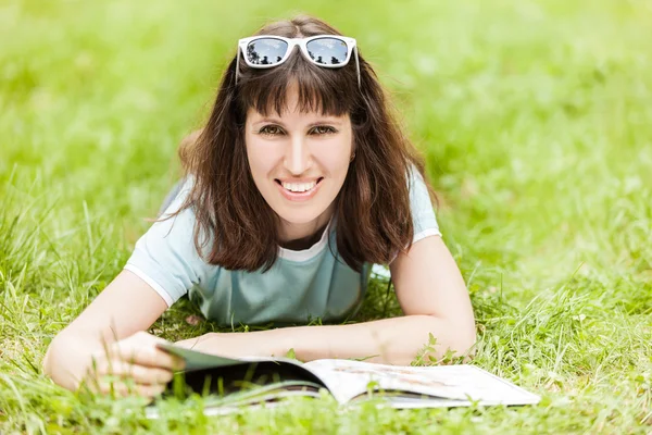 微笑的女人阅读本书室外的美容 — 图库照片