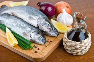 Close-up raw fish trout on a wooden board clipart