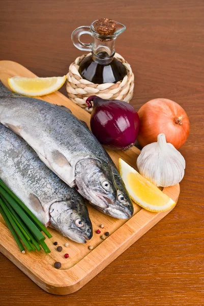 Čerstvé syrové ryby s bylinkami a kořením na kuchyňské desce — Stock fotografie
