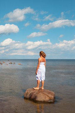 Woman on stone. clipart