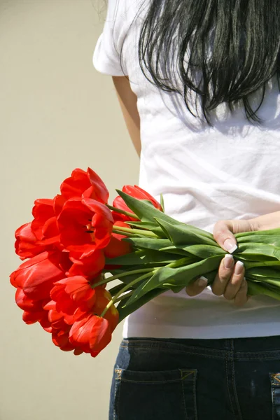 Девушка с красными тюльпанами в руке — стоковое фото