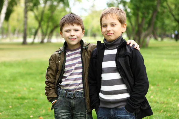 Niño con un amigo en el parque verde —  Fotos de Stock