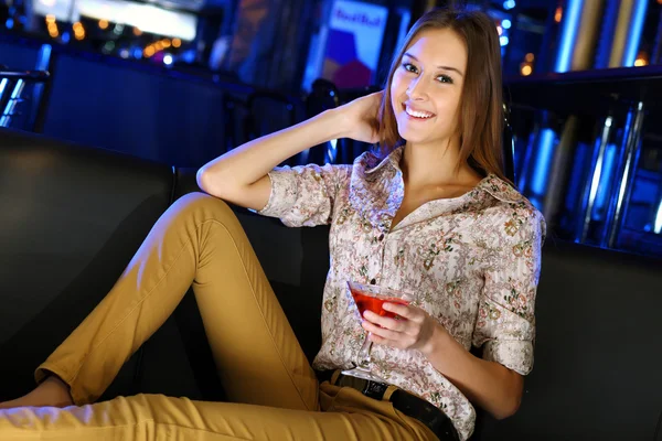 Attractive woman in night club with a drink Stock Photo