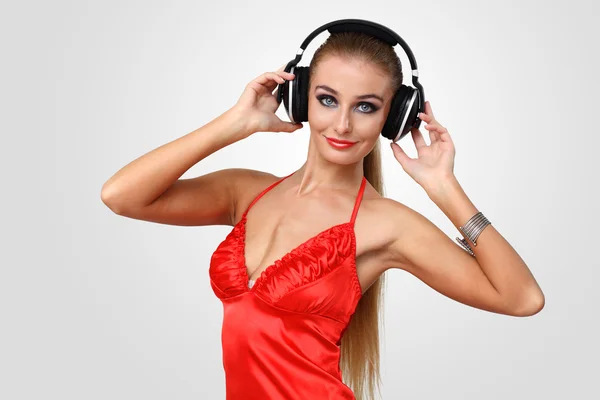 Молода жінка в вечірній сукні з навушниками — стокове фото
