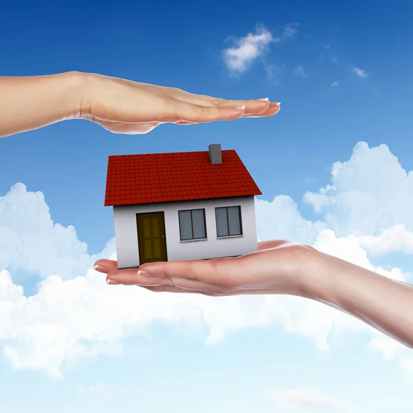 Haus und menschliche Hand gegen blauen Himmel — Stockfoto