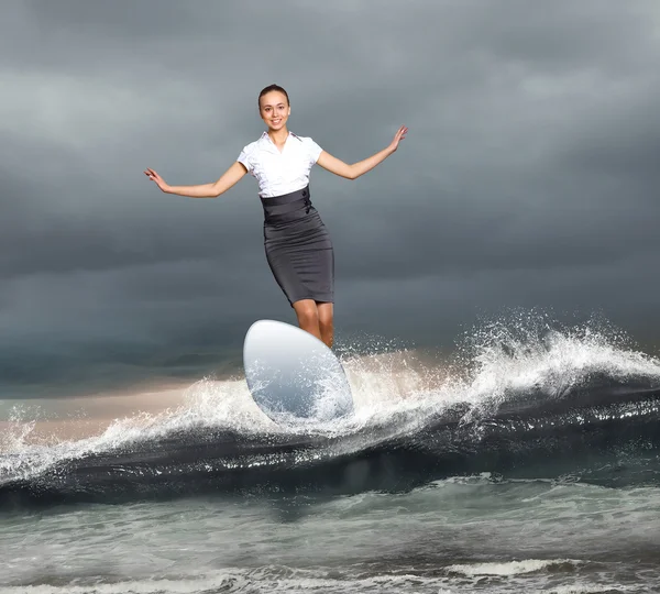 Zakenvrouw surfen op de golven van de zee — Stockfoto