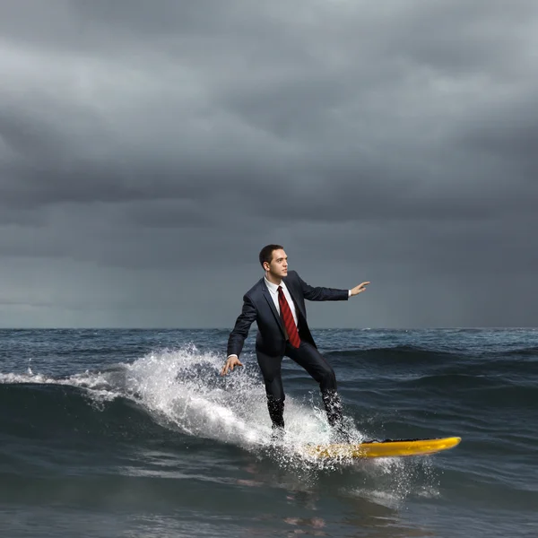 Genç bir iş kişi dalgaların sörf — Stok fotoğraf