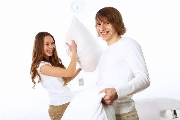 Young couple fighting with pillows — Stock Photo, Image