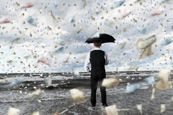 Soldi pioggia e uomo d'affari con ombrello — Foto Stock