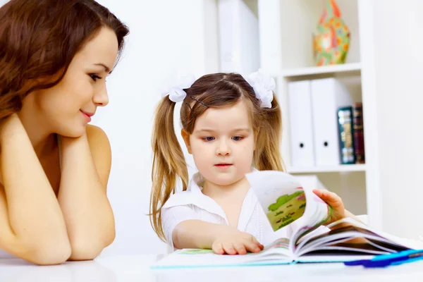 Klein meisje en haar moeder studeren — Stockfoto