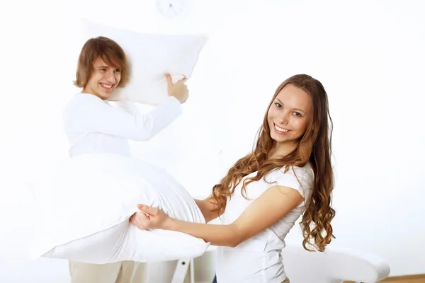 Casal jovem lutando com travesseiros — Fotografia de Stock