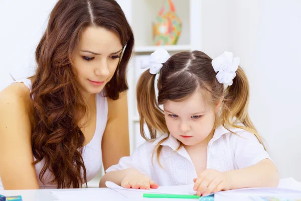 Klein meisje en haar moeder studeren — Stockfoto