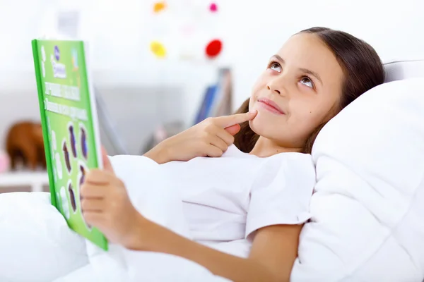 Chica con un libro en la cama en casa — Foto de Stock