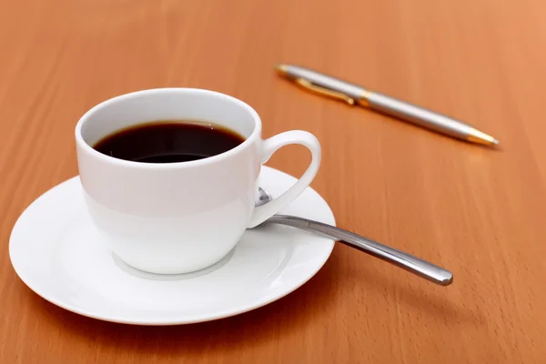Svart kaffe i en kopp och penna — Stockfoto