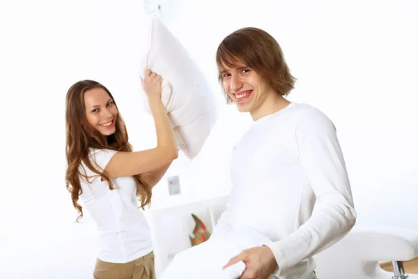 Young couple fighting with pillows — Stock Photo, Image