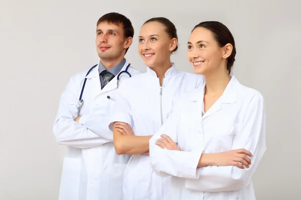 Tres médicos jóvenes en uniforme blanco —  Fotos de Stock