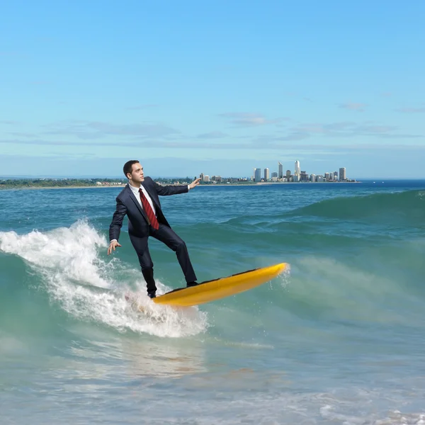 Jonge bedrijfspersoon surfen op de golven — Stockfoto