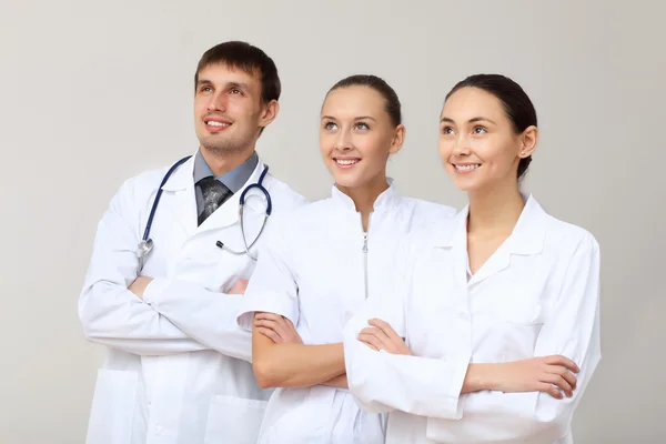 Trois jeunes médecins en uniforme blanc — Photo