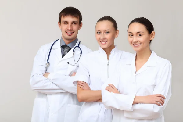 Três jovens médicos de uniforme branco — Fotografia de Stock