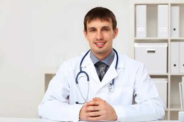 Jonge mannelijke arts in witte uniform Stockfoto