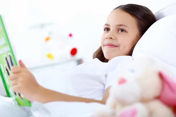 stock image Girl with a book in bed at home