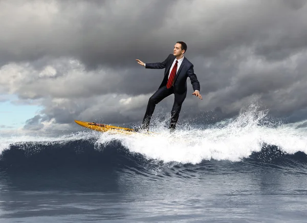 Jonge bedrijfspersoon surfen op de golven — Stockfoto
