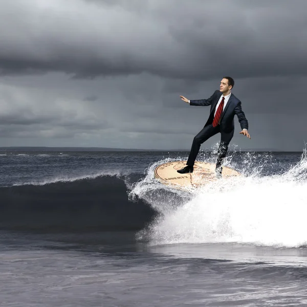 Joven hombre de negocios surfeando en las olas — Foto de Stock