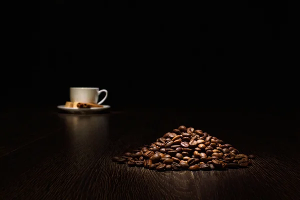 Кофейные зерна и белая чашка — стоковое фото