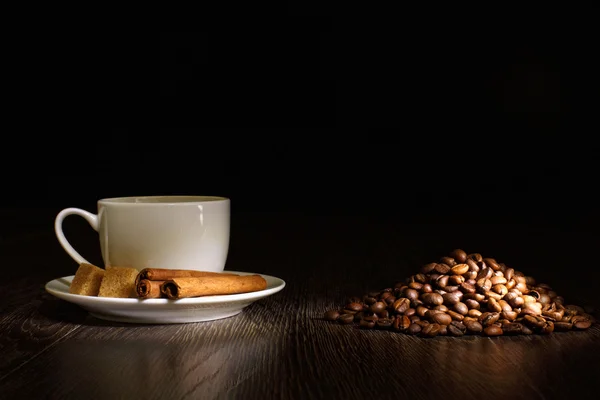 Кавові зерна та біла чашка — стокове фото
