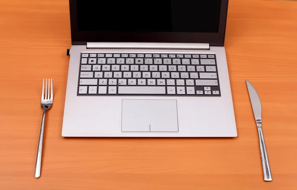 Laptop computer with fork and knife — Stock Photo, Image