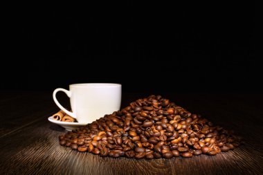 Kahve çekirdekleri ve beyaz bardak.