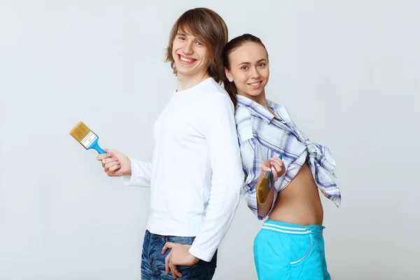 Couple with paint brushes — Stock Photo, Image