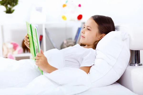 Mädchen mit Buch zu Hause im Bett — Stockfoto