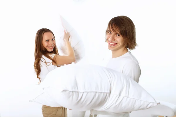 Молодая пара дерётся с подушками — стоковое фото