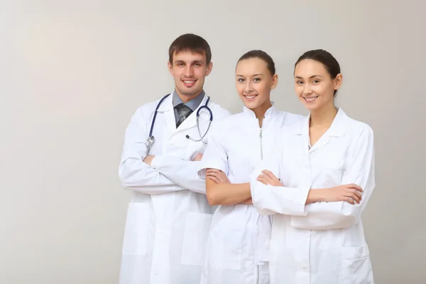 Tre unga läkare i vit uniform — Stockfoto