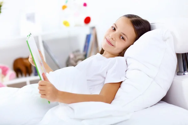 Κορίτσι με ένα βιβλίο στο κρεβάτι στο σπίτι — Φωτογραφία Αρχείου