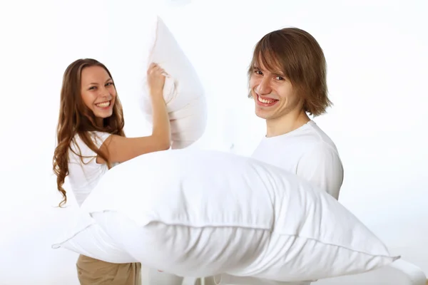 Молодая пара дерётся с подушками — стоковое фото