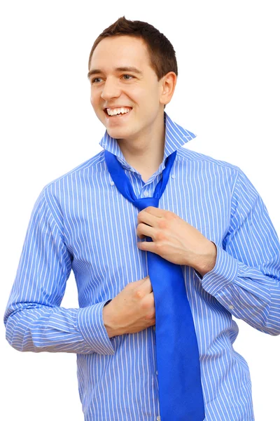 Joven hombre de negocios atando su corbata azul — Foto de Stock