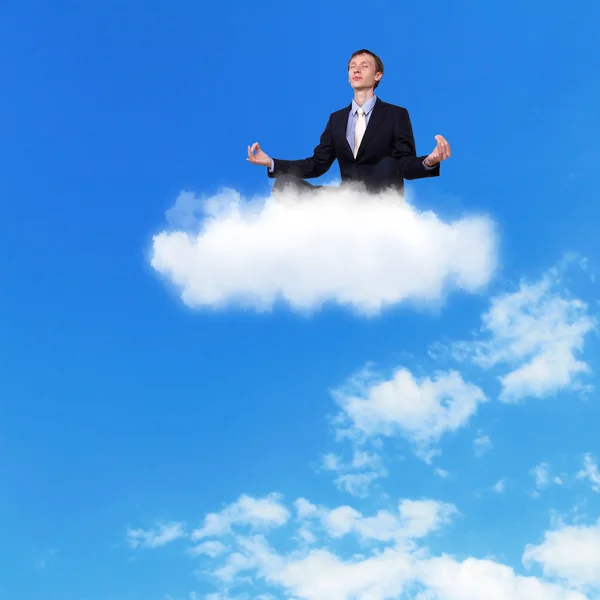 Бизнесмен медитирует сидя на облаке — стоковое фото