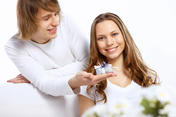 Young couple at home with present — Stockfoto