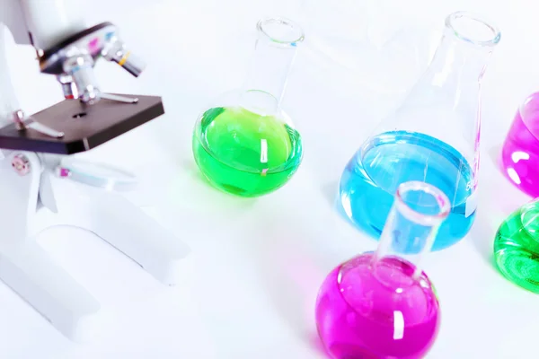 Chemistry laboratory glassware with colour liquids — Stock Photo, Image