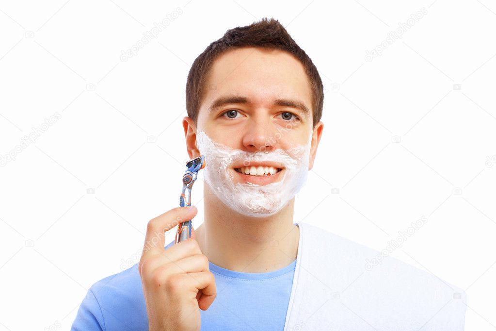 Young man at home shaving himself