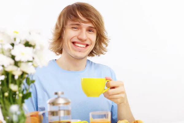 Młody człowiek szczęśliwy, picie herbaty — Zdjęcie stockowe