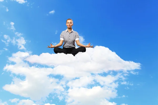 Businesswoman meditating sitting on the cloud — Stock Photo, Image
