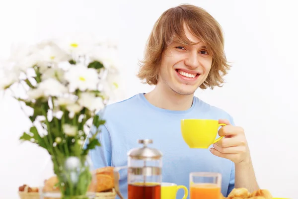 Young happy man drinking tea — Stock Photo, Image