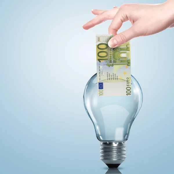 Dinheiro dentro de uma lâmpada elétrica — Fotografia de Stock