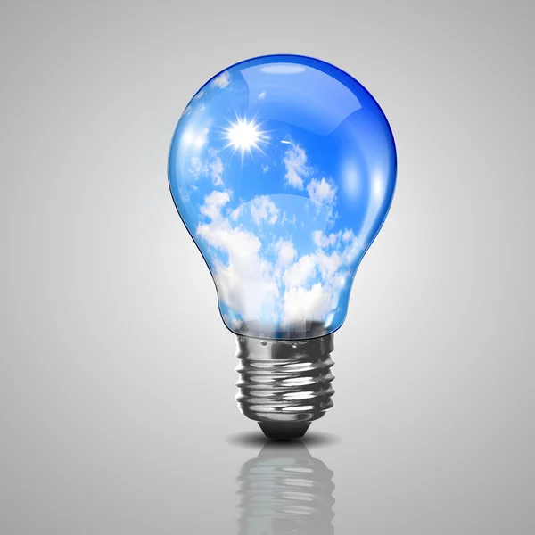 Electric light bulb and blue sky inside it — Stock Photo, Image