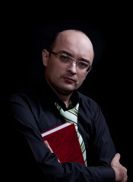 Mann mit Brille hält rotes Buch in der Hand. — Stockfoto